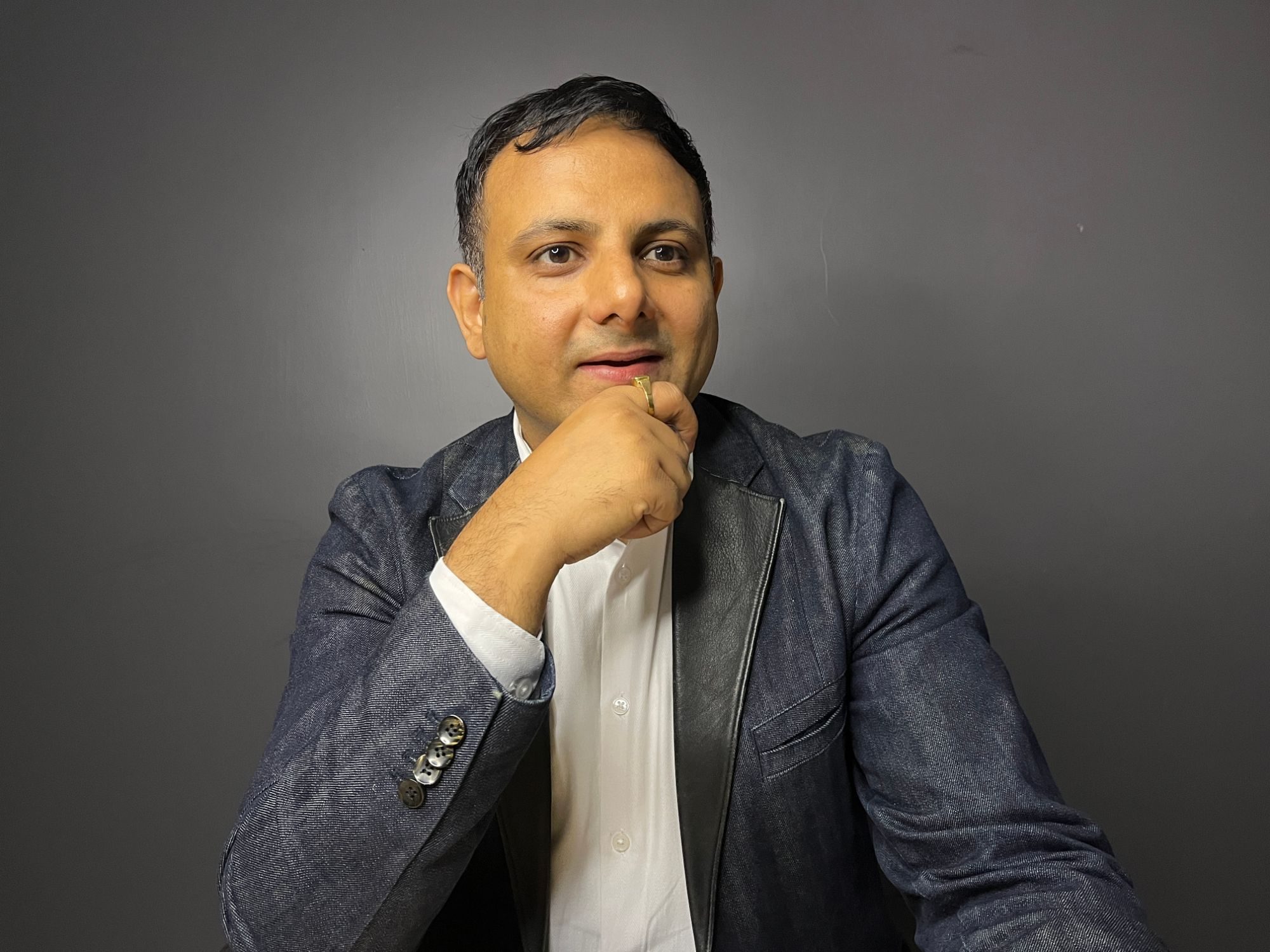Gaurav Singhal in a denim blazer, hand on chin